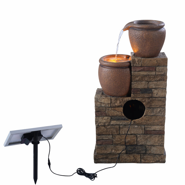 A view from behind of the fountain featuring where the pump is inserted inside and the lead to the solar panel