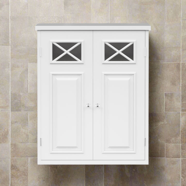 White wall-mounted bathroom cabinet with decorative cross-patterned glass insets on the doors, set against a beige tiled wall.